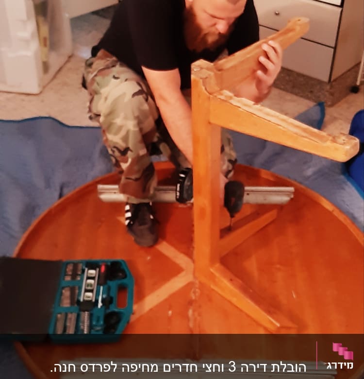 אדם מפרק שולחן עגול בעזרת כלי עבודה